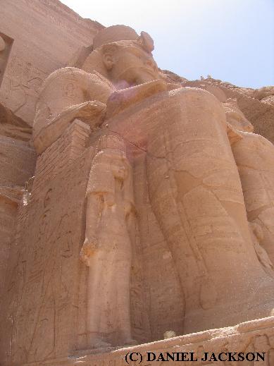 Kleine Figur der Nefertari neben dem Unterschenkel einer großen Sitzstatue von Ramses II